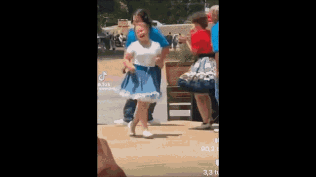 a woman is holding a little girl in her arms while they dance .