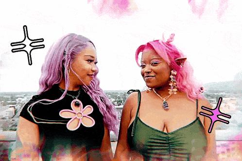 two women with pink hair are standing next to each other and one has a flower on her shirt