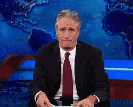 a man in a suit and tie is sitting in front of a map