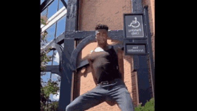 a man is standing in front of a building with a handicapped sign on it
