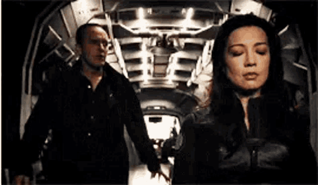 a man and woman are standing next to each other in a dark room .