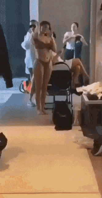 a woman in a bikini takes a picture of herself in a mirror