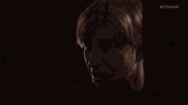 a close up of a man 's face with a konami logo behind him