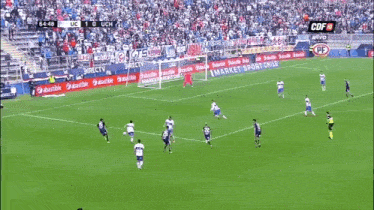 a soccer game is being played in front of a crowd with advertisements for mercado sport chile