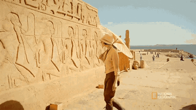 a man stands in front of a national geographic advertisement