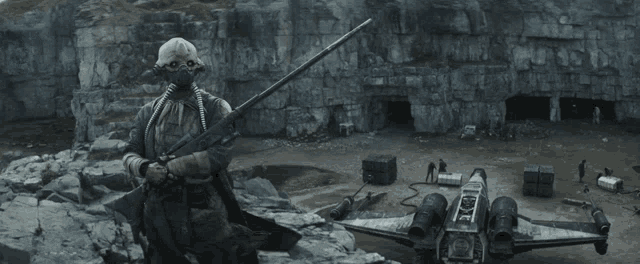 a man in a gas mask is holding a gun in front of a star wars plane