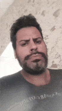 a man with a beard and mustache is wearing a black shirt that says ' i 'm to go ' on it