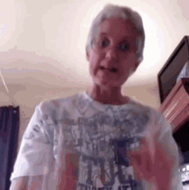 an older woman wearing a t-shirt that says ' chicago ' on it is standing in a room .