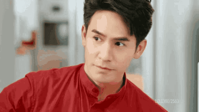 a man in a red shirt is looking to the side