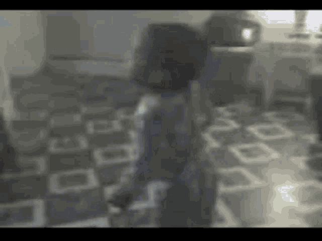 a blurry picture of a person standing on a checkered floor in a room .