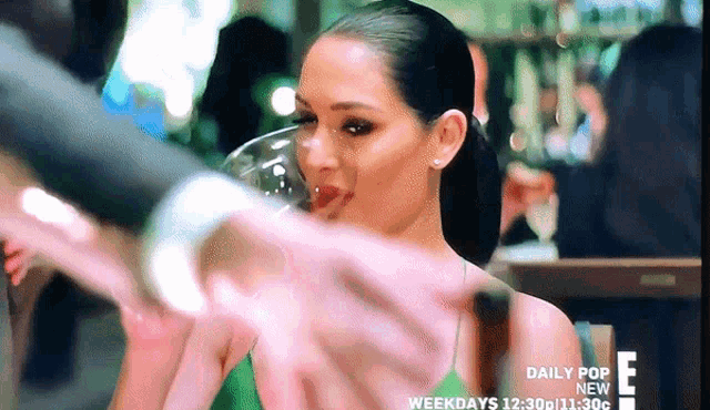 a woman in a green tank top drinking from a glass with daily pop new written on the bottom