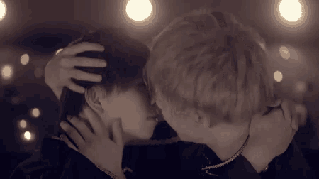 a man and woman kissing in front of a blurred background
