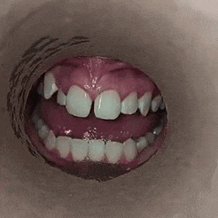 a close up of a person 's mouth with their teeth showing .
