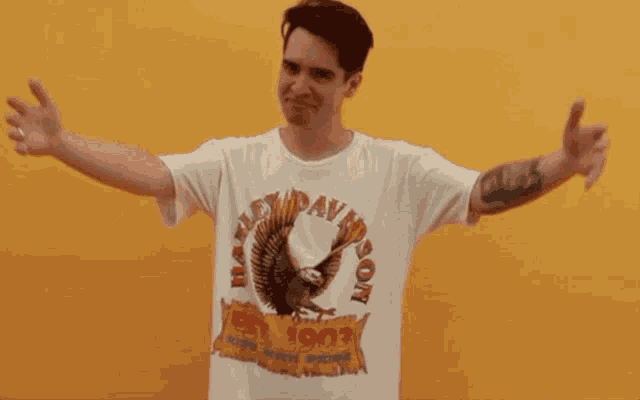 a man wearing a harley davidson t-shirt is standing with his arms outstretched