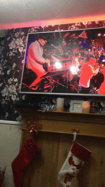 a christmas stocking hangs on a mantle next to a television