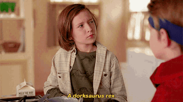 a young boy says a dorksaurus rex while sitting at a table