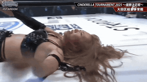 a woman is laying on the ground in a wrestling ring with cinderella tournament 2025 written on the bottom
