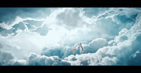 a couple of birds are flying through the clouds in the sky