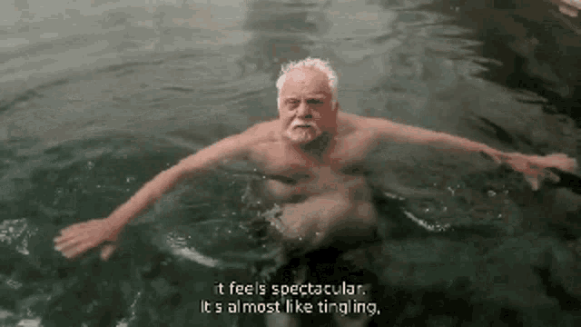 a shirtless man is swimming in a pool and says it feels spectacular