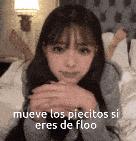 a girl is laying on a bed with the words mueve los piecitos si eres de floo written on the bottom
