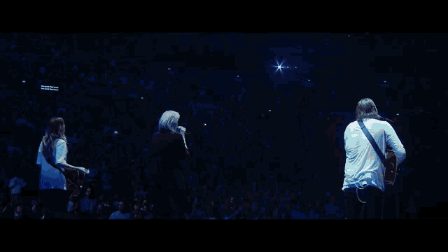 a crowd of people raising their arms in the air