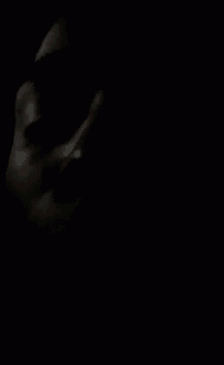 a close up of a person 's face in the dark with a black background .