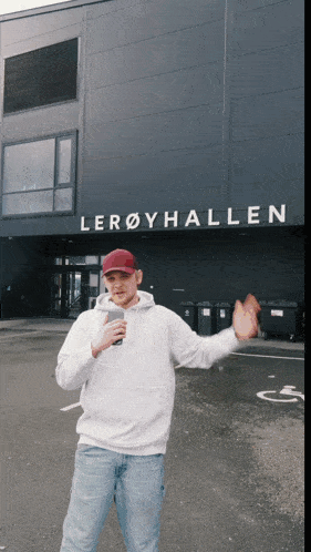 a man is standing in front of a building that says leroyhallen