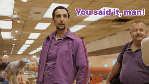 a man in a purple jacket is standing next to another man who says you said it man