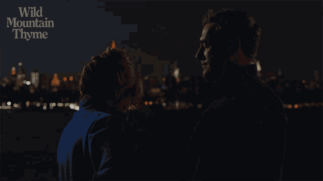 a couple kissing in front of a city skyline with wild mountain thyme written on the bottom