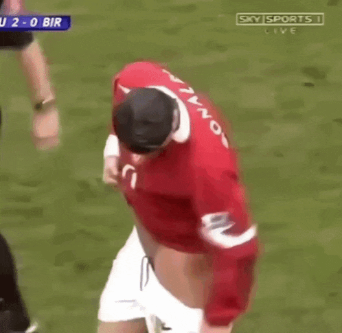 a soccer player is taking off his shirt during a match on sky sports