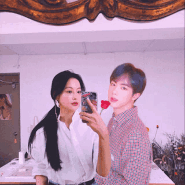 a man and a woman are taking a picture of themselves in front of a mirror