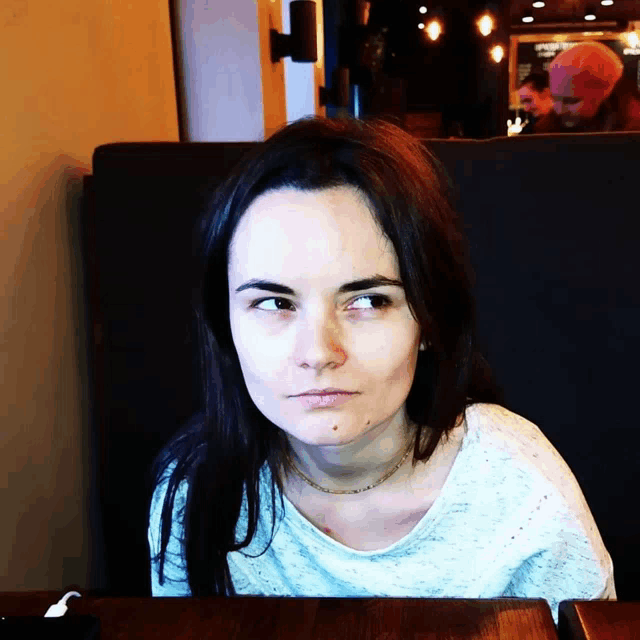 a woman sitting at a table with her eyes looking up