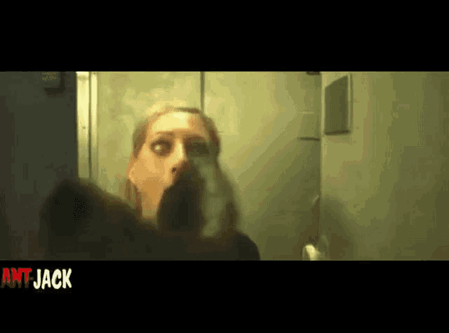 a woman is looking at herself in a mirror in a dark room .