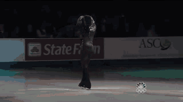 a female figure skater is performing in front of a state farm ad