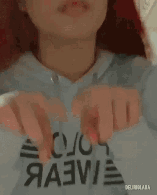 a woman with red hair is wearing a white hoodie that says ' aa3w ' on it .