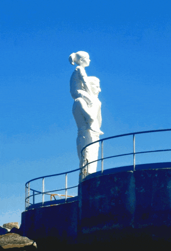 a statue of a woman carrying a child on her back
