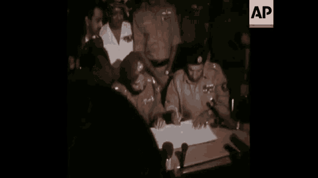 a group of people are sitting at a table in front of a crowd .