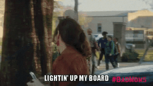 a woman in a brown jacket is holding a cell phone and says lightin ' up my board