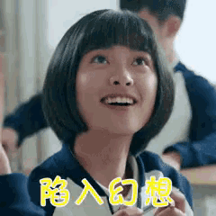 a girl with short hair is sitting at a desk in a classroom and smiling .