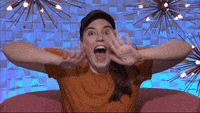 a woman is sitting on a pink couch with her mouth open and her hands on her face .