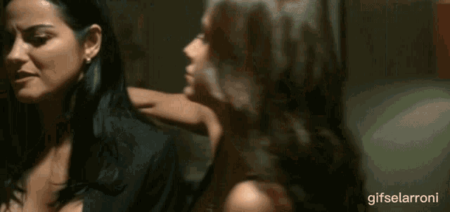 a woman kissing a man in front of a red candle with gifselarroni written below it
