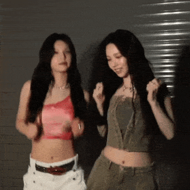two young women are standing next to each other and dancing .