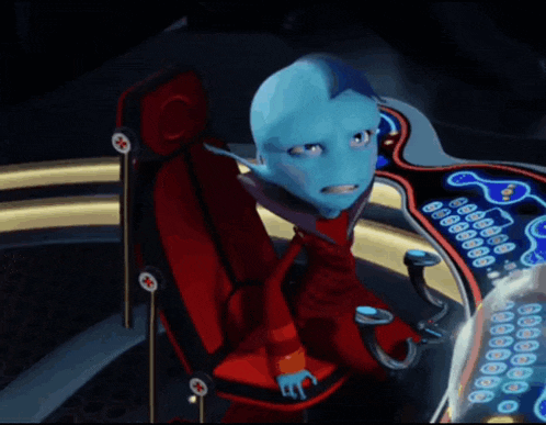a blue alien is sitting in a red chair in front of a computer screen