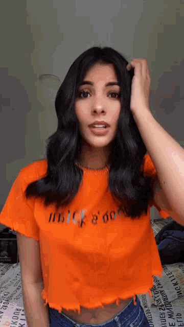 a woman wearing an orange t-shirt that says " juice & dope "