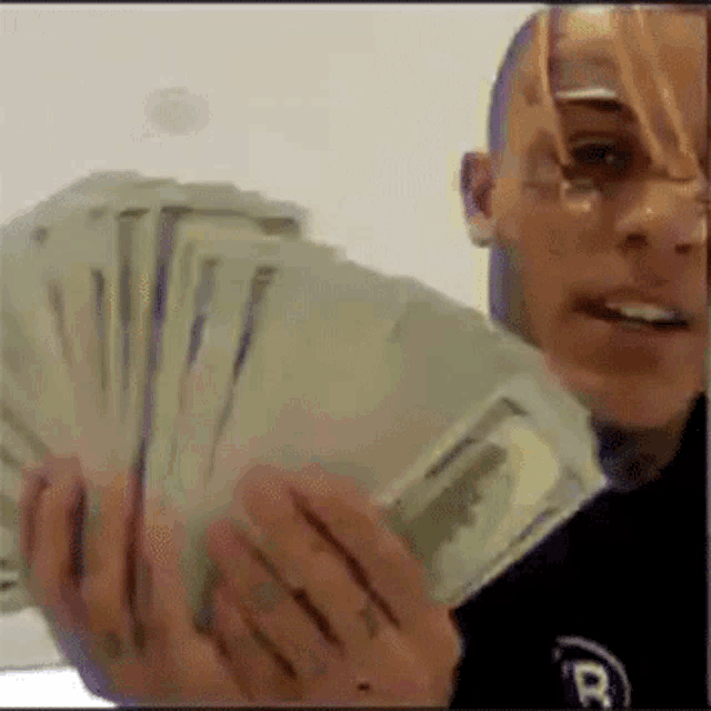 a man is holding a bunch of money in his hands .