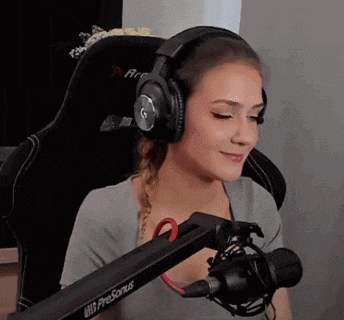 a woman wearing headphones is sitting in front of a microphone in a chair .