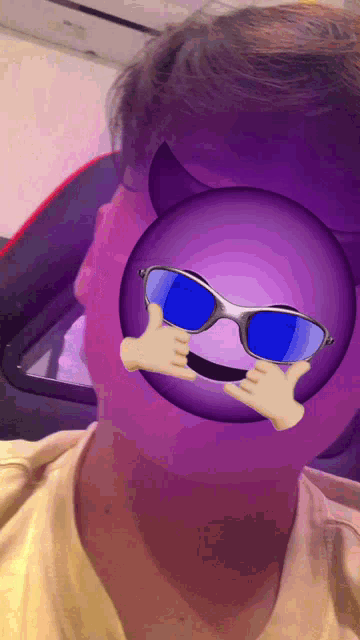 a person wearing sunglasses and a purple smiley face