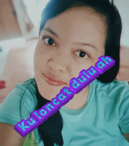 a woman in a blue shirt has a purple sticker on her face that says kaliancat duuh