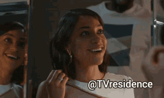 a woman is smiling in front of a mirror with the hashtag @tvresidence