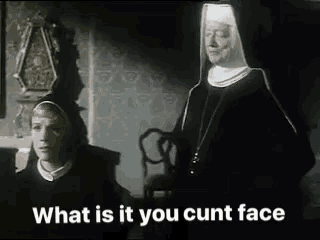 two nuns are standing next to each other in a room and one of them is saying `` what is it you cunt face '' .